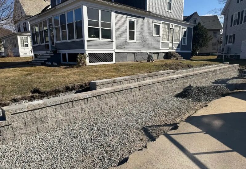 Gray retaining wall in residential backyard.