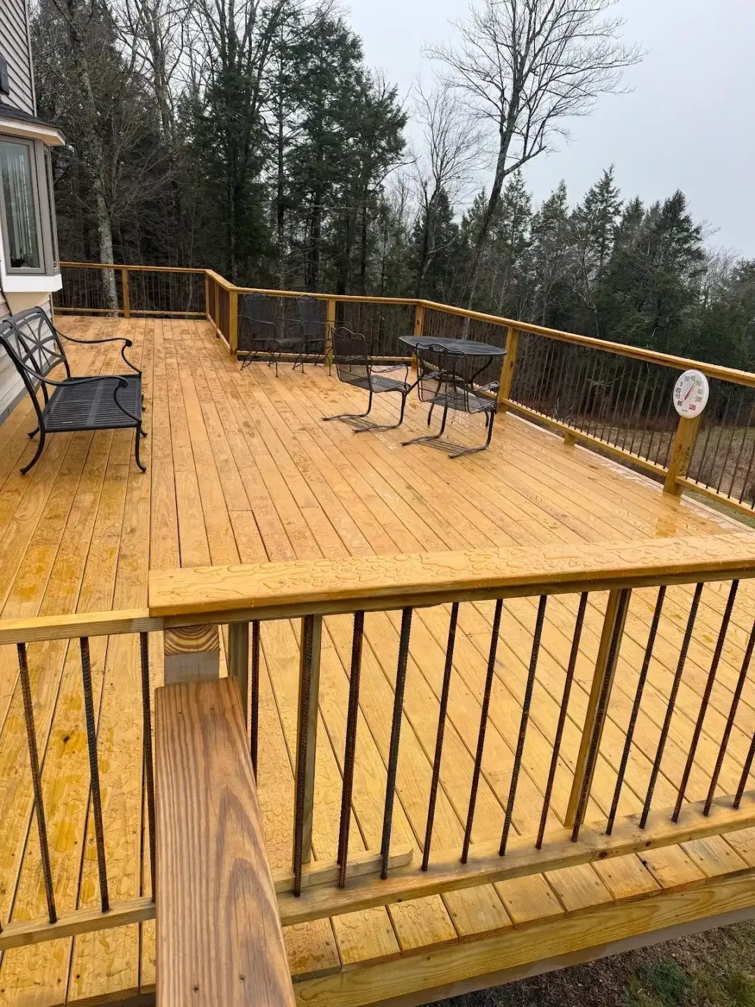 Wooden deck with benches and railing.